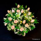 Centro de rosas, alstroemerias y flores de complemento en colores suaves.