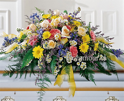 Hermoso cojín cubre-urnas confeccionado con una muestra de flores variadas de la estación. Flores pueden cambiar según disponibilidad de de Stock